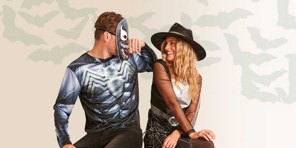 A woman and man dressed in a witch and Venom Halloween costumes.